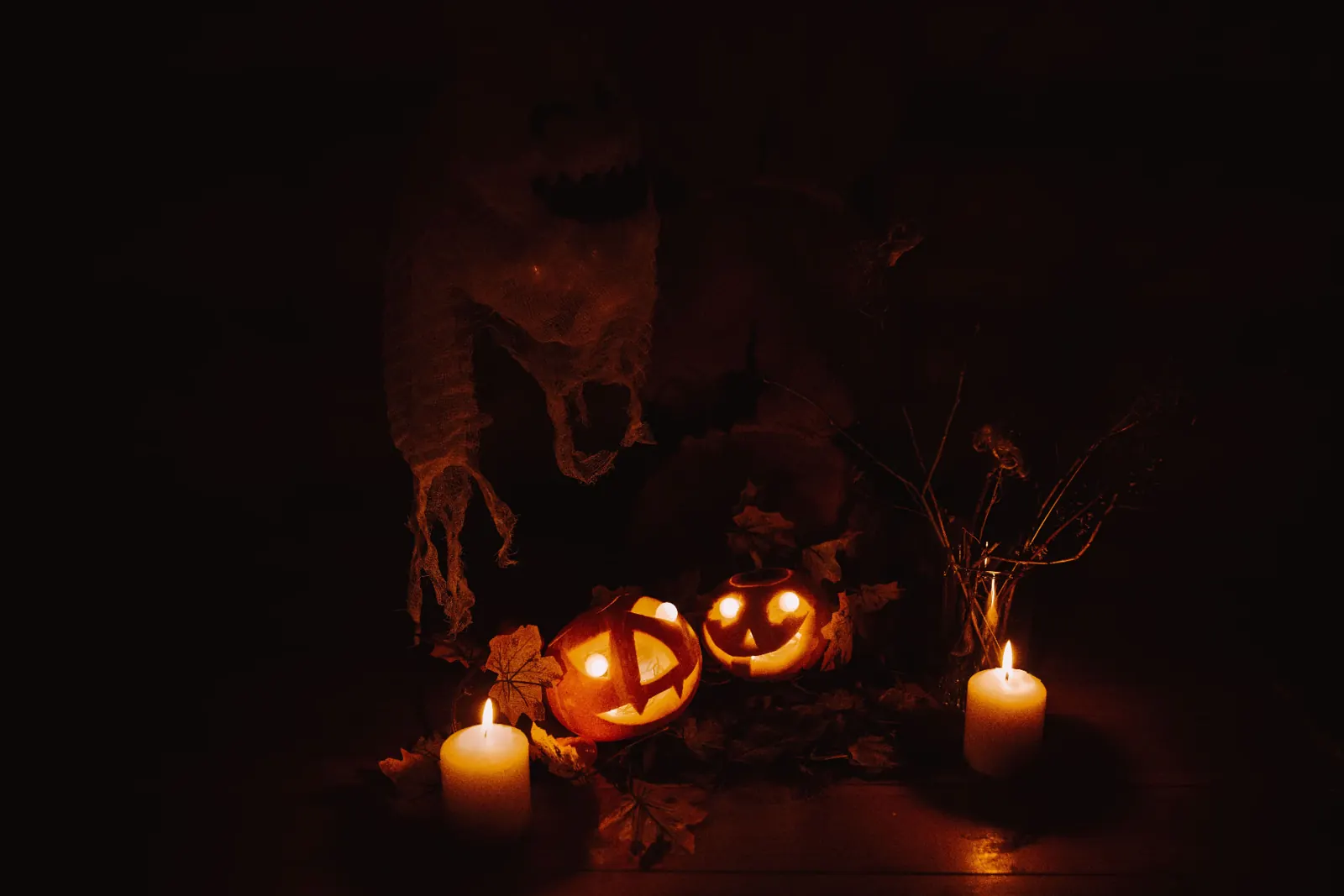 Seasonal atmosphere: jack-o'-lanterns, candles and a draped ghost (stock photo)